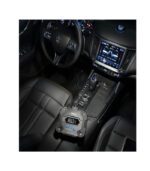 A sleek black car interior with advanced tech and a portable device on the center console.