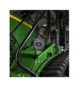 Close-up of a green John Deere tractor cabin and tire.